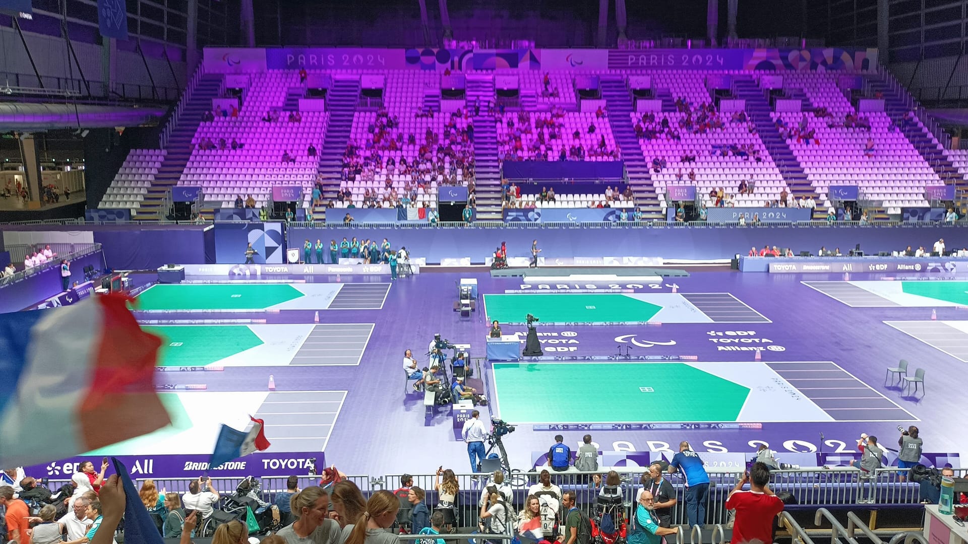 A packed arena at the Paris 2024 Paralympic Games, with three boccia courts in play below the stands
